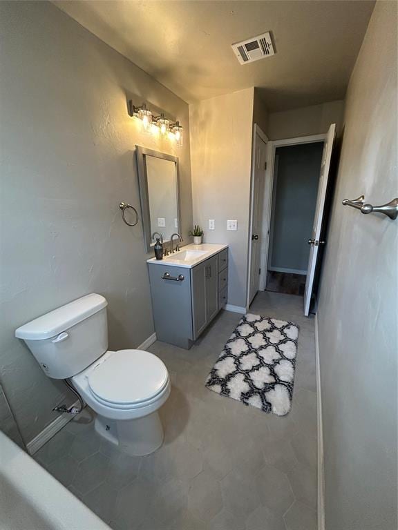 half bathroom with baseboards, visible vents, vanity, and toilet