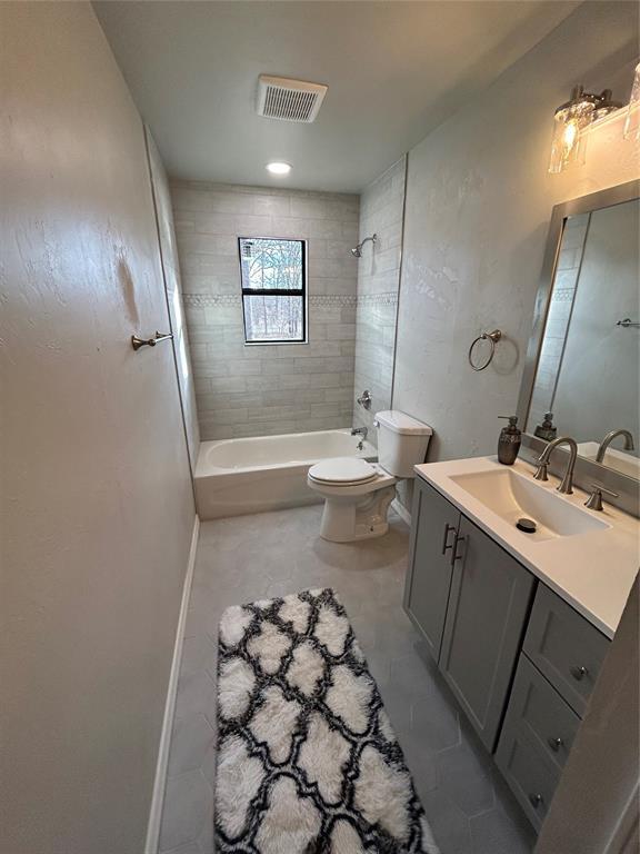 bathroom with toilet, vanity, visible vents, and bathing tub / shower combination