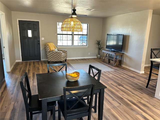 dining area featuring visible vents, baseboards, and wood finished floors