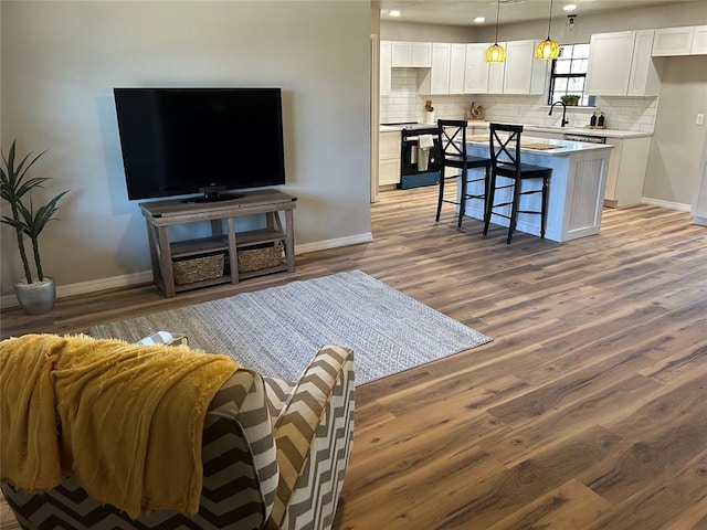 living room featuring baseboards, dark wood-type flooring, and recessed lighting