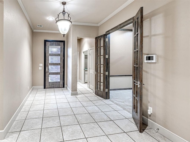 tiled foyer with crown molding and french doors