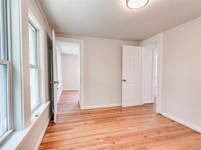 unfurnished room with crown molding and light hardwood / wood-style floors