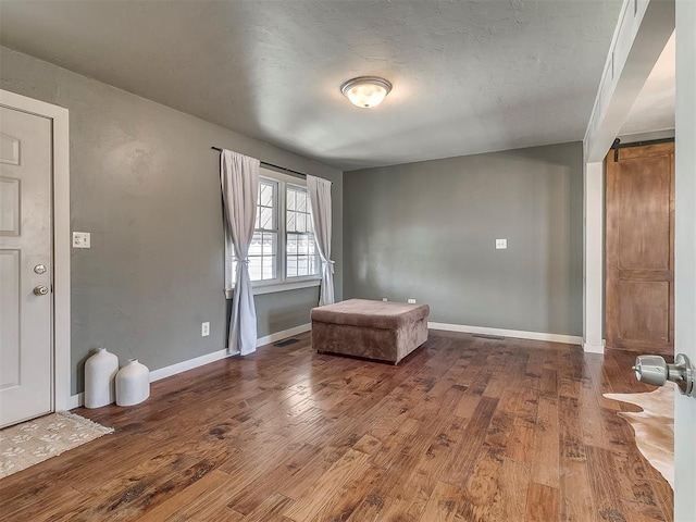 spare room with hardwood / wood-style flooring and a barn door