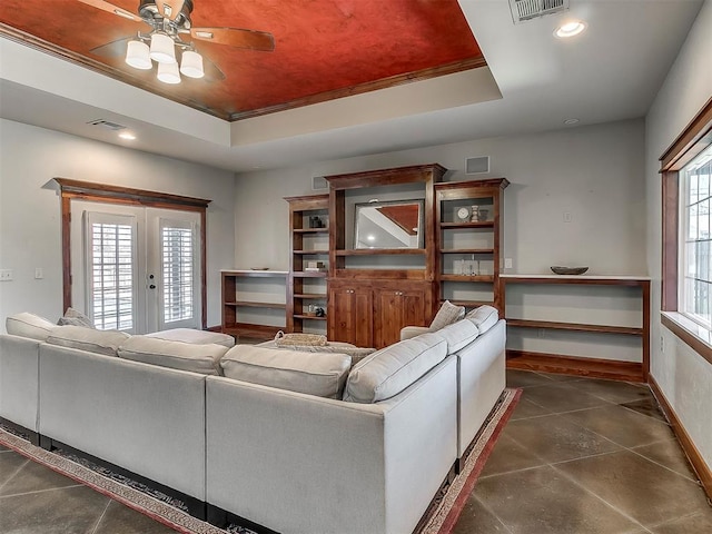 living room featuring french doors, ceiling fan, ornamental molding, and a tray ceiling