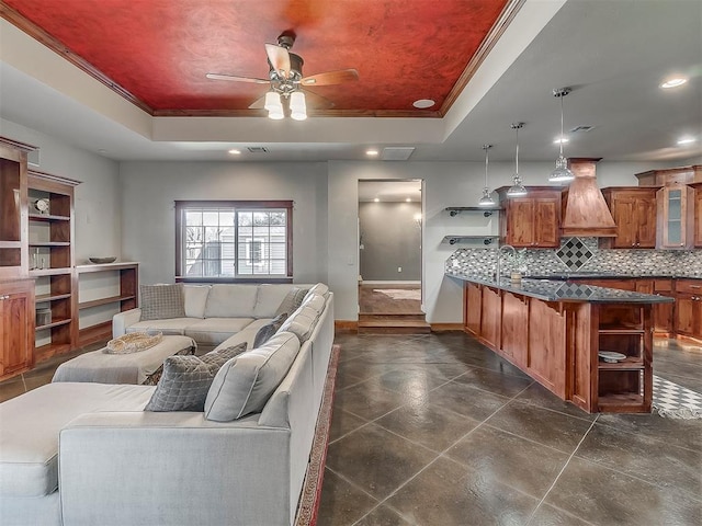 living room featuring crown molding, a tray ceiling, and ceiling fan