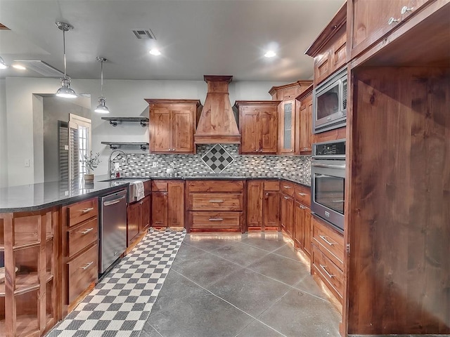 kitchen with sink, tasteful backsplash, hanging light fixtures, custom range hood, and stainless steel appliances