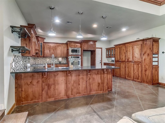 kitchen featuring appliances with stainless steel finishes, decorative light fixtures, tasteful backsplash, a kitchen breakfast bar, and kitchen peninsula