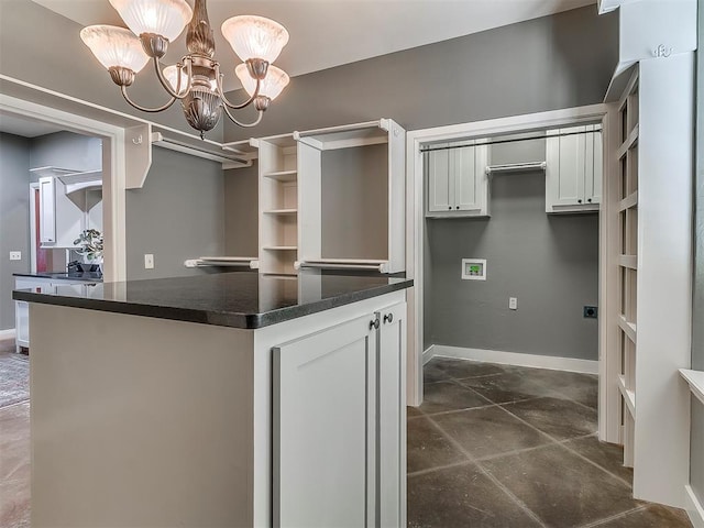 kitchen with white cabinetry, pendant lighting, kitchen peninsula, and an inviting chandelier