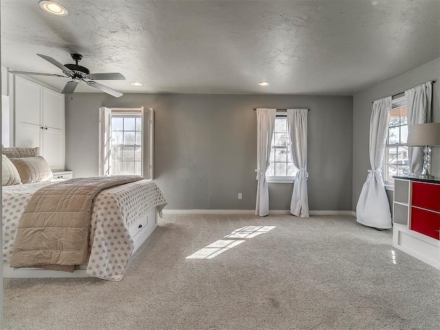 carpeted bedroom featuring a textured ceiling and ceiling fan