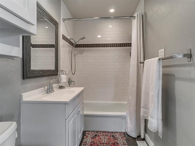 full bathroom featuring vanity, shower / bath combination with curtain, and toilet