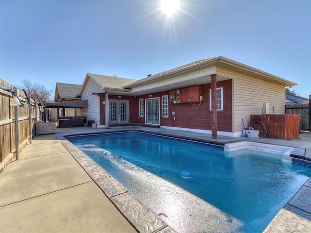 view of swimming pool with a hot tub, a patio, and french doors