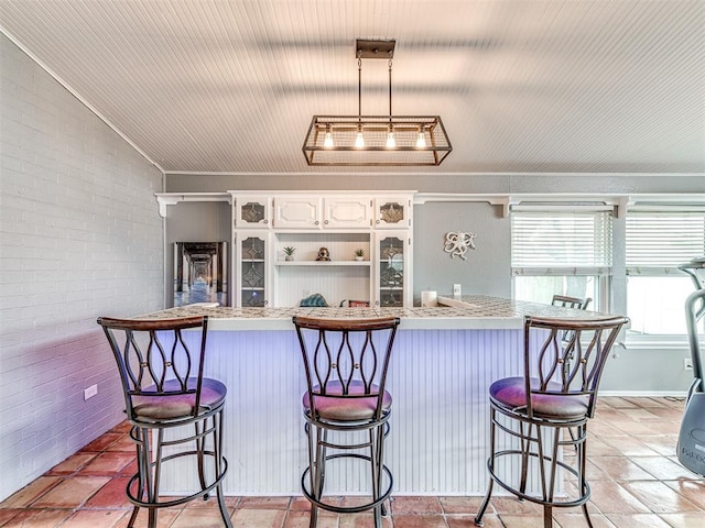 kitchen with white cabinetry, a kitchen bar, and decorative light fixtures