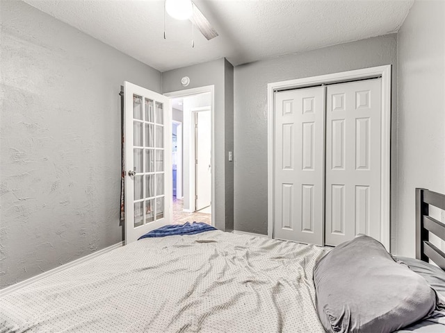 bedroom with ceiling fan, a closet, and a textured ceiling