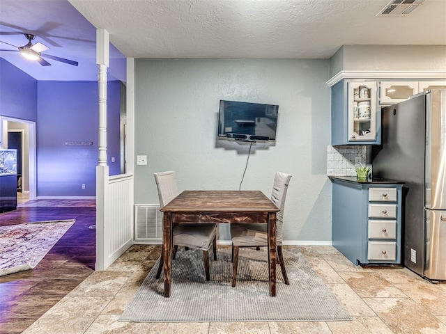 dining space featuring ceiling fan and a textured ceiling