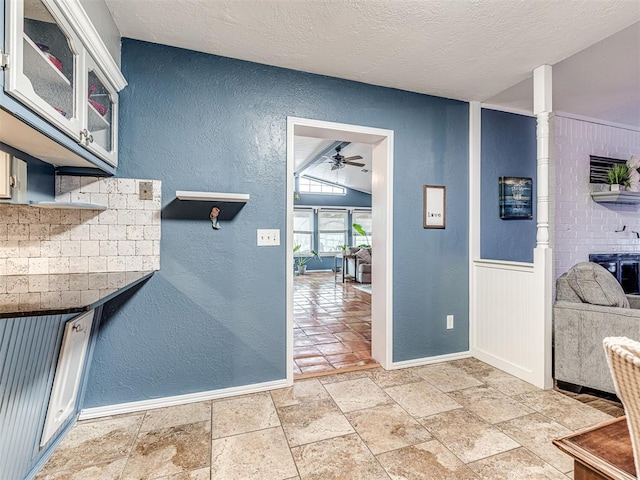 kitchen with white cabinets, a textured ceiling, and ceiling fan