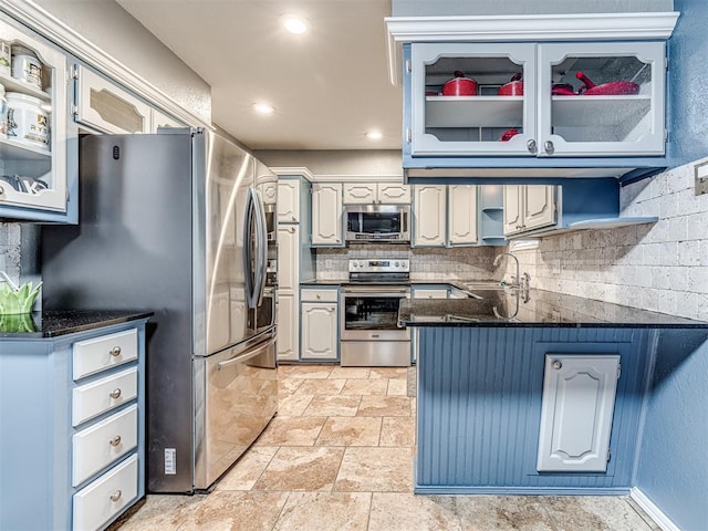 kitchen featuring tasteful backsplash, sink, kitchen peninsula, and appliances with stainless steel finishes