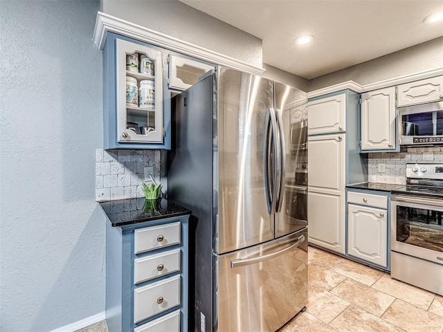 kitchen with dark stone countertops, backsplash, and appliances with stainless steel finishes