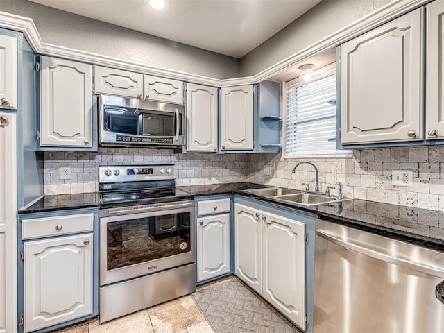 kitchen with white cabinetry, appliances with stainless steel finishes, sink, and decorative backsplash