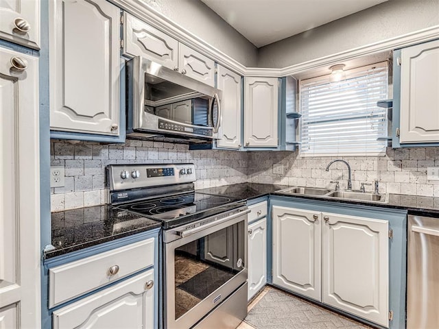 kitchen with tasteful backsplash, stainless steel appliances, sink, and white cabinets