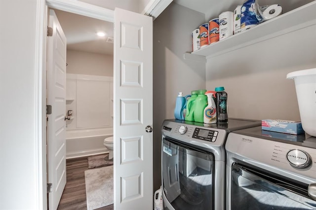 washroom featuring dark hardwood / wood-style flooring and washing machine and clothes dryer