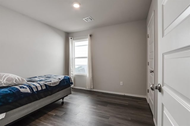 bedroom with dark hardwood / wood-style floors