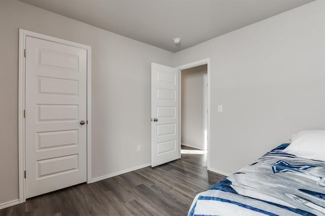 bedroom with dark hardwood / wood-style floors