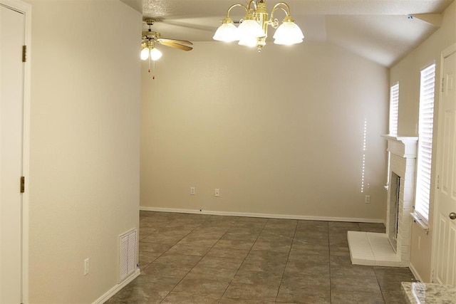 empty room featuring dark tile patterned flooring, vaulted ceiling, and ceiling fan