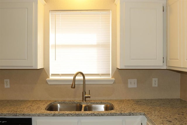 kitchen with white cabinetry, light stone countertops, sink, and dishwashing machine