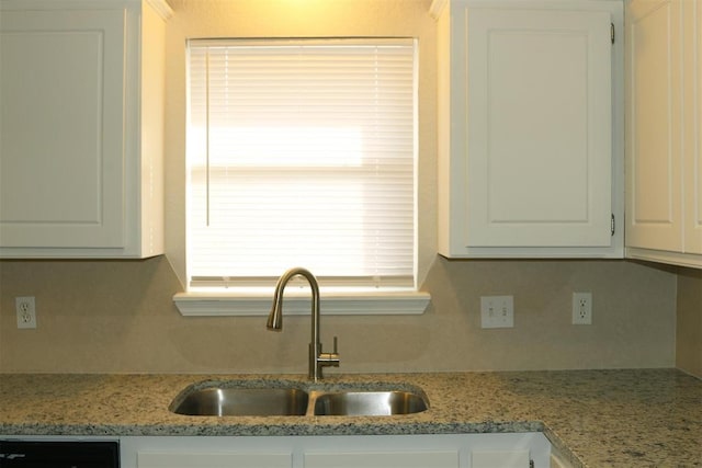 kitchen featuring white cabinetry, dishwasher, sink, and light stone counters