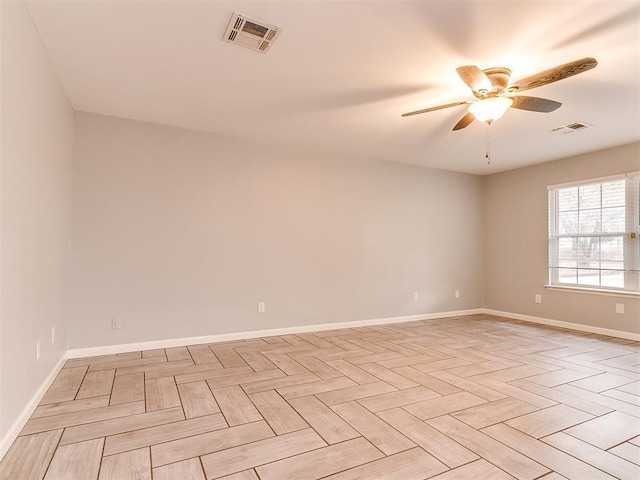 spare room featuring ceiling fan, baseboards, and visible vents