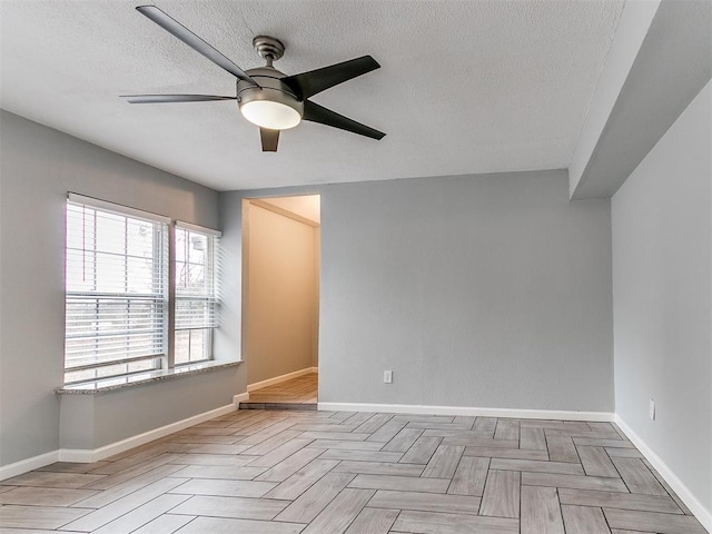 empty room featuring baseboards, a textured ceiling, and ceiling fan