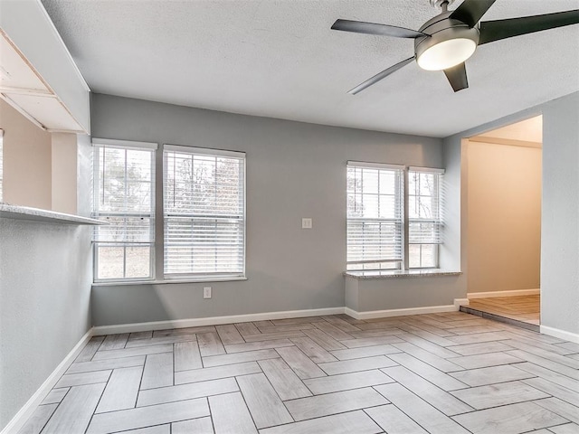 spare room featuring a textured ceiling, ceiling fan, and a healthy amount of sunlight