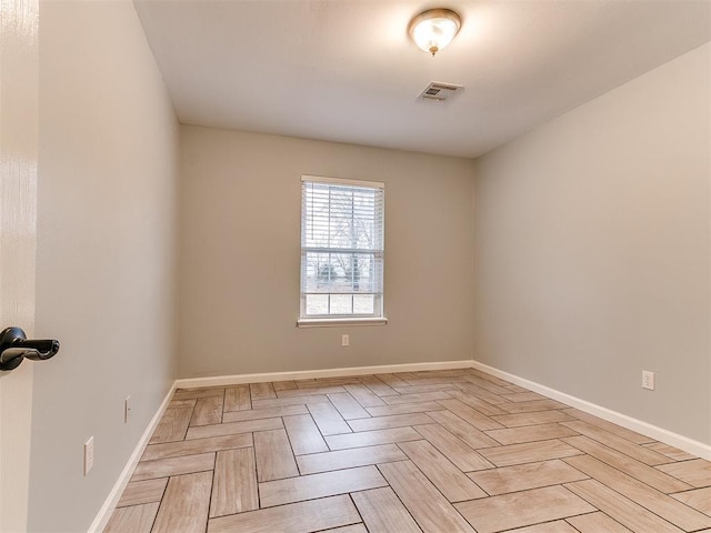 empty room with baseboards and visible vents