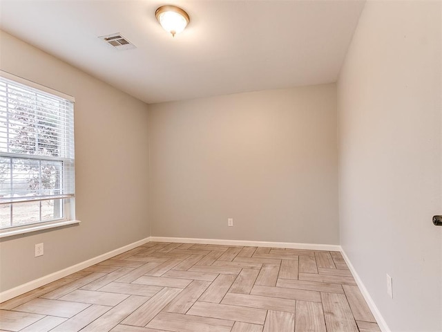 empty room featuring visible vents, baseboards, and a healthy amount of sunlight