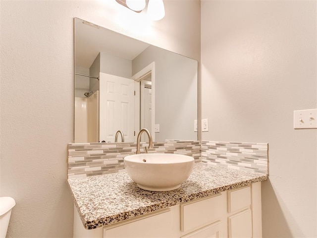 bathroom with tasteful backsplash and vanity