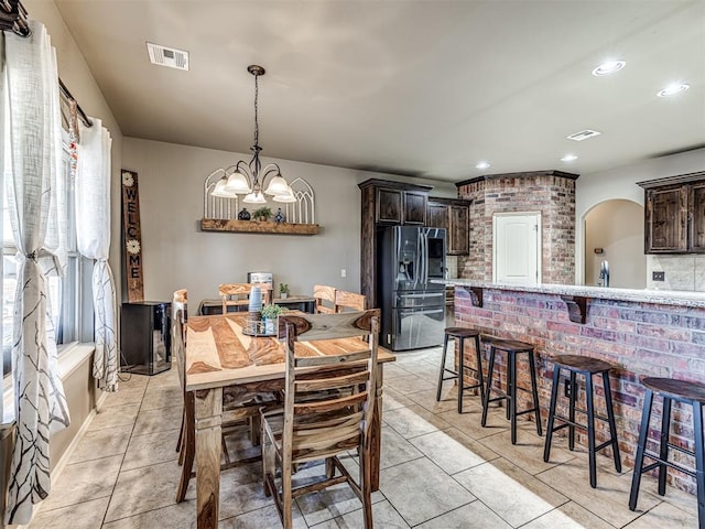 dining space with light tile patterned floors and a notable chandelier