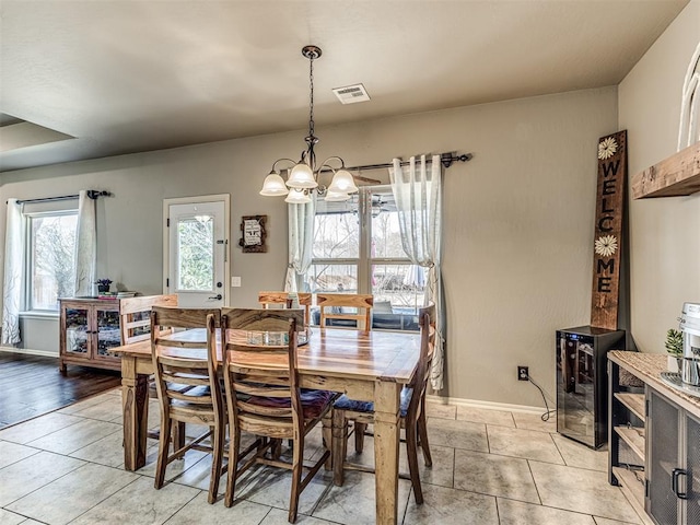 tiled dining space with an inviting chandelier