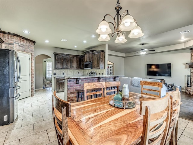 dining room featuring sink, ceiling fan with notable chandelier, and light tile patterned floors