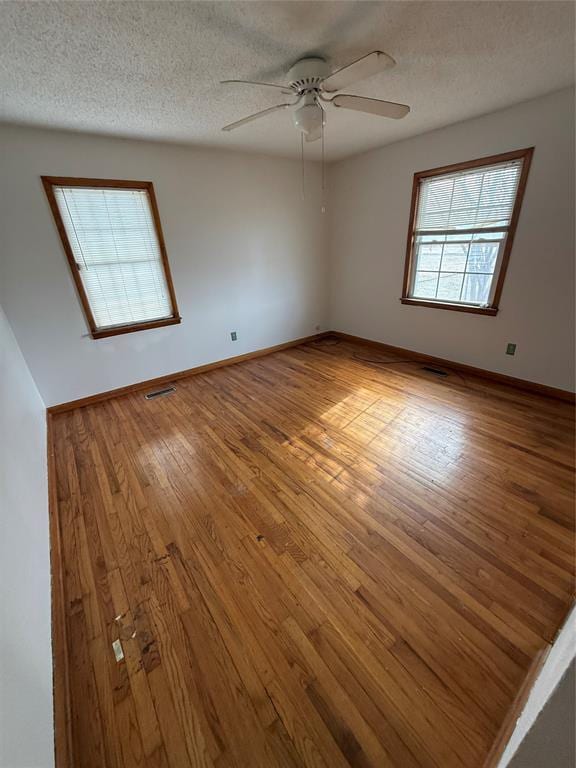 unfurnished room featuring a textured ceiling, light hardwood / wood-style floors, and ceiling fan