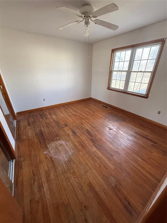 empty room with hardwood / wood-style flooring and ceiling fan