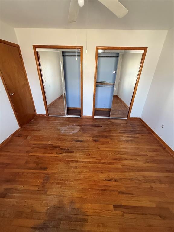 unfurnished bedroom with ceiling fan and dark hardwood / wood-style flooring