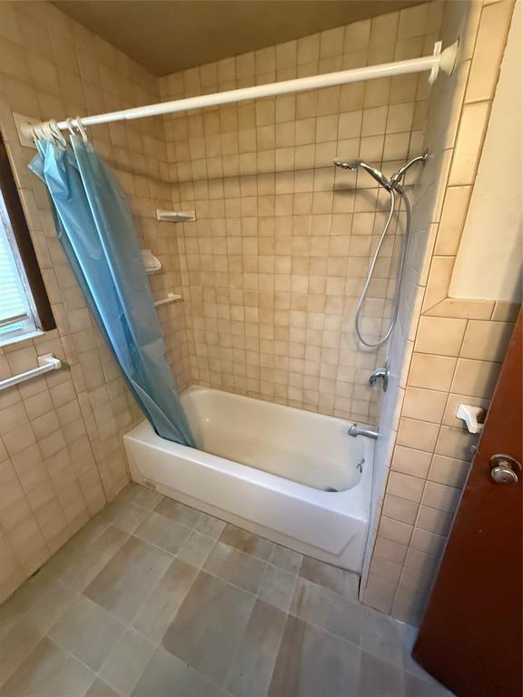 bathroom with tile walls, tile patterned floors, and shower / bath combo