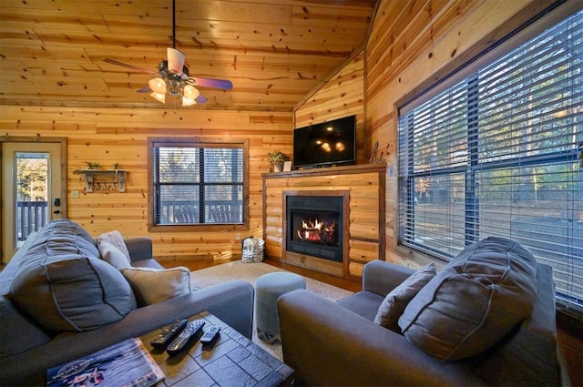 living room featuring wood ceiling, vaulted ceiling, ceiling fan, and wood walls