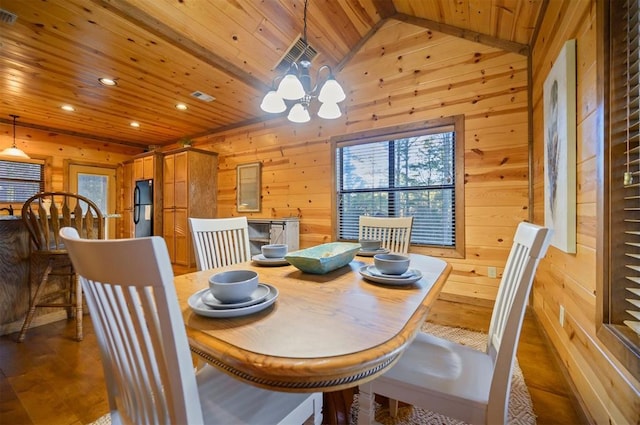 dining space featuring wood ceiling, lofted ceiling, a chandelier, and wood walls