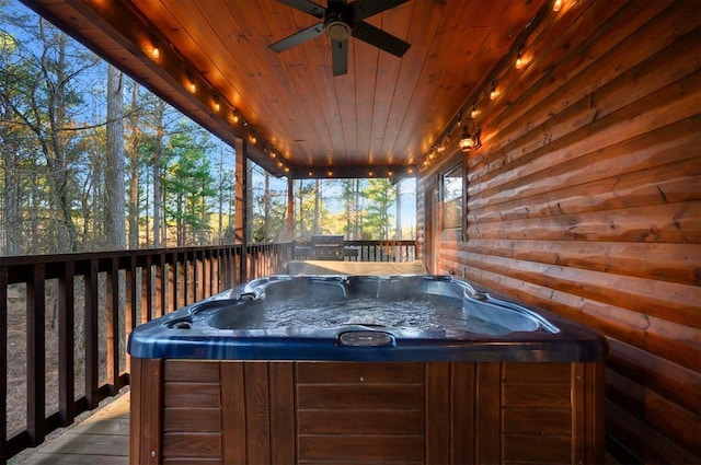 wooden deck with ceiling fan and a hot tub