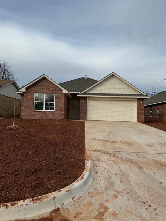 single story home with brick siding, driveway, an attached garage, and roof with shingles