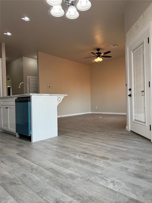 kitchen with ceiling fan with notable chandelier, dishwashing machine, light hardwood / wood-style floors, and white cabinets