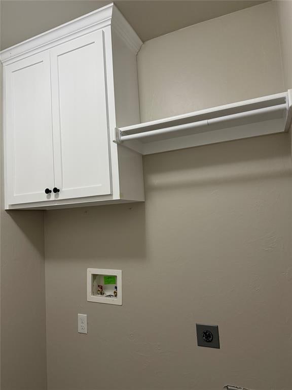 laundry room with electric dryer hookup, hookup for a washing machine, and cabinets