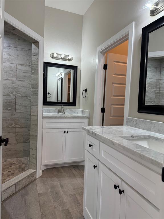 bathroom featuring vanity and tiled shower