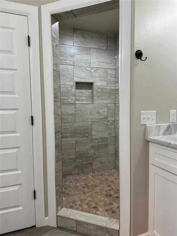 bathroom with vanity and a tile shower